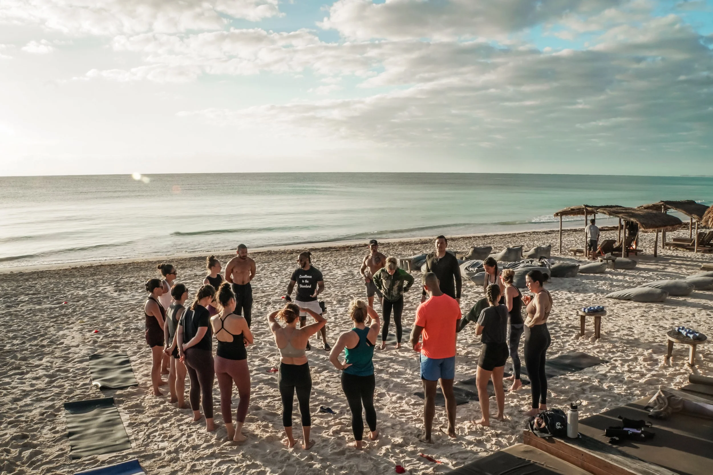 Picture of a group of friends working out on Tulum Beach and an Amansala Fitness Retreat in Mexico.