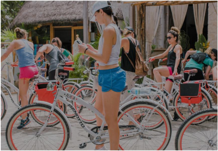 Women looks at directions on a bike during her solo trip to tulum, mexico