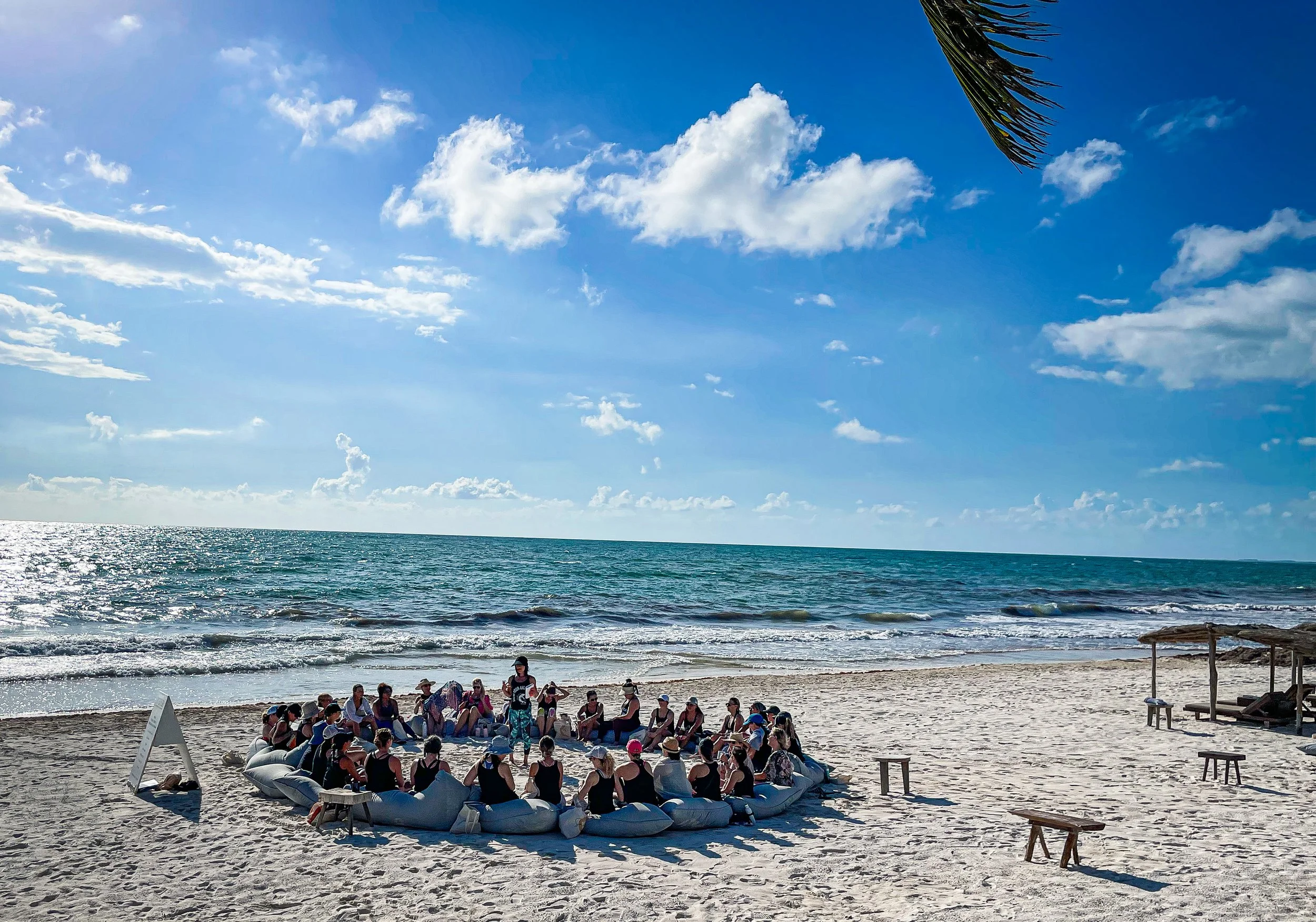 women join in a group activity on the beach as part of Amansala's solo travel packages