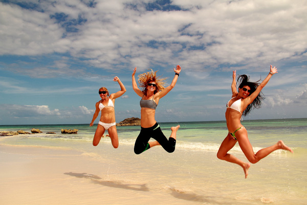 Girls jumping on the beach at Tulum